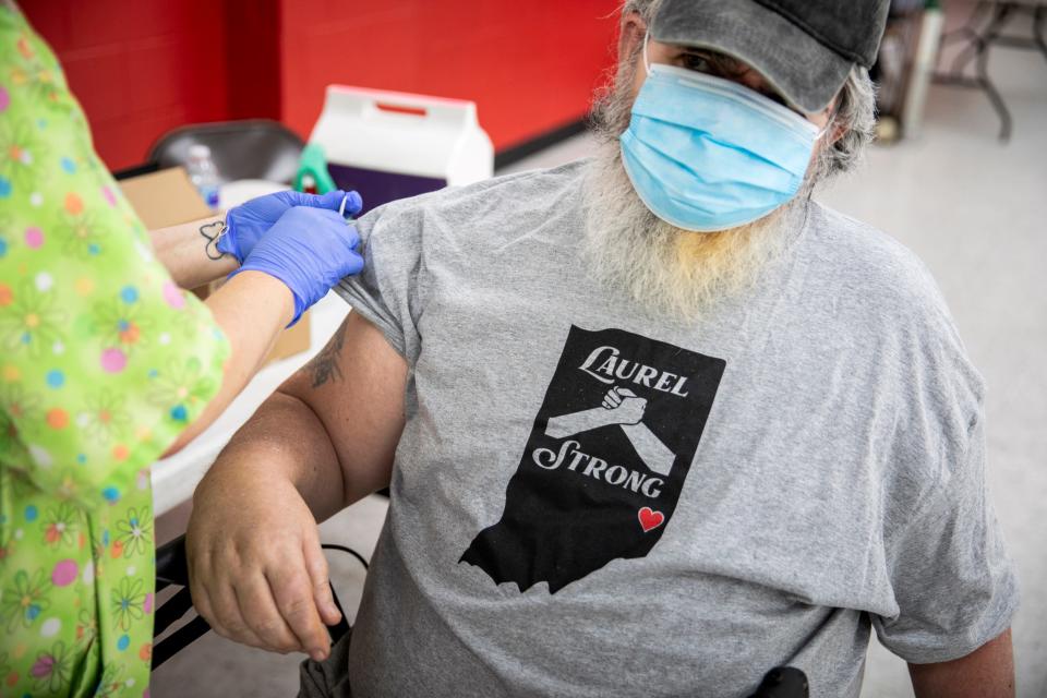 Angie Ruther, a registered nurse with the Franklin County, Indiana, Health Department, administers a COVID-19 vaccine to a man wearing a masked man on June 7, 2021.