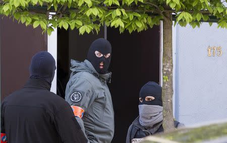 Belgian and French police secure access during a police operation to search an apartment complex in the Brussels district of Uccle, Belgium, April 12, 2016. REUTERS/Yves Herman