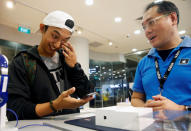 Kent Lee, 20, the first customer in queue, reacts after getting his new iPhone 7 at an Apple reseller shop in Singapore September 16, 2016. REUTERS/Edgar Su