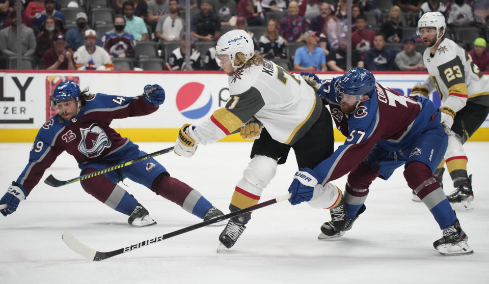 Vegas Golden Knights center William Karlsson, center, drives between Colorado Avalanche defenseman Samuel Girard and left wing J.T. Compher, right, to put a shot on goal during the third period of Game 5 of an NHL hockey Stanley Cup second-round playoff series Tuesday, June 8, 2021, in Denver. (AP Photo/David Zalubowski)