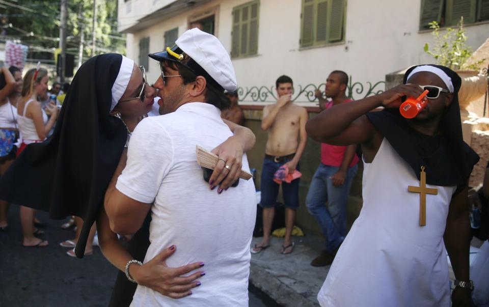 Revellers kiss each other during the annual block party known as "Carmelitas" in Rio de Janeiro February 13, 2015. Contrary to a common stereotype, Brazil is a socially conservative nation, its culture rooted in Catholic tradition. Many view the five-day Carnival as the one chance to enjoy a bit of hedonism before the solemn period of Lent begins on Ash Wednesday. Some locals measure that freedom in kisses, competing with their friends to see who can smooch 10, 20, even 30 different people in a single outing. Picture taken on February 13, 2015. REUTERS/Pilar Olivares (BRAZIL - Tags: SOCIETY)