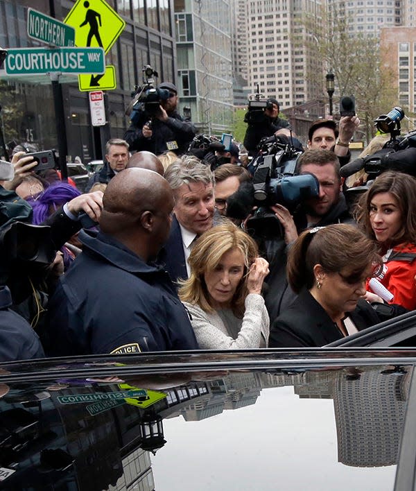 Felicity Huffman, center, gets into a vehicle on May 13 outside federal court in Boston, where she pleaded guilty to charges in the college admissions bribery scandal.