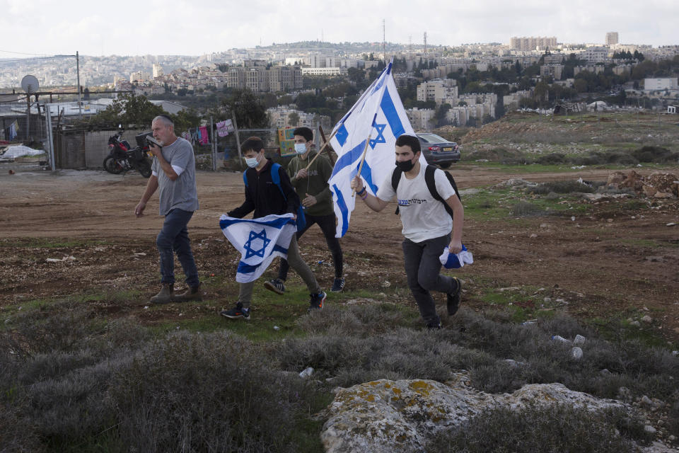 FILE - In this Nov. 16, 2020, file, photo, protesters arrive to heckle a news conference by European Union officials visiting the construction site for Givat Hamatos settlement in Jerusalem. Israel is quietly advancing controversial settlement projects in and around Jerusalem while refraining from major announcements that could anger the Biden administration. Critics say Israel is paving the way for rapid growth when the political climate changes. (AP Photo/Maya Alleruzzo, File)