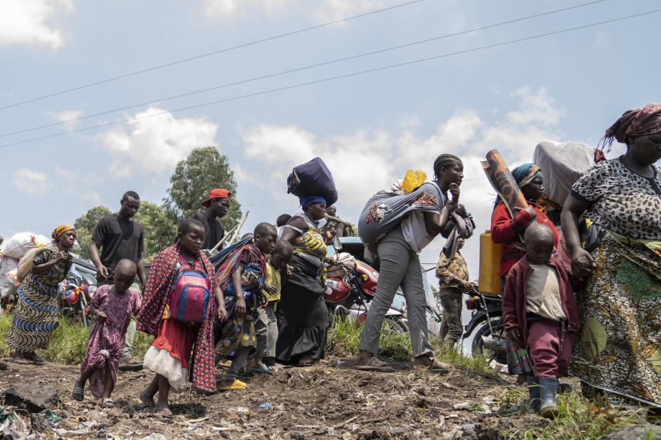 Thousands who are fleeing the ongoing conflict between government forces and M-23 rebels reach the entrance the Democratic Republic of Congo eastern city of Goma Wednesday, Feb. 7, 2024. (AP Photo/Moses Sawasawa)