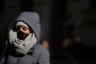 A woman wears a mask on Wall St. near the NYSE in New York