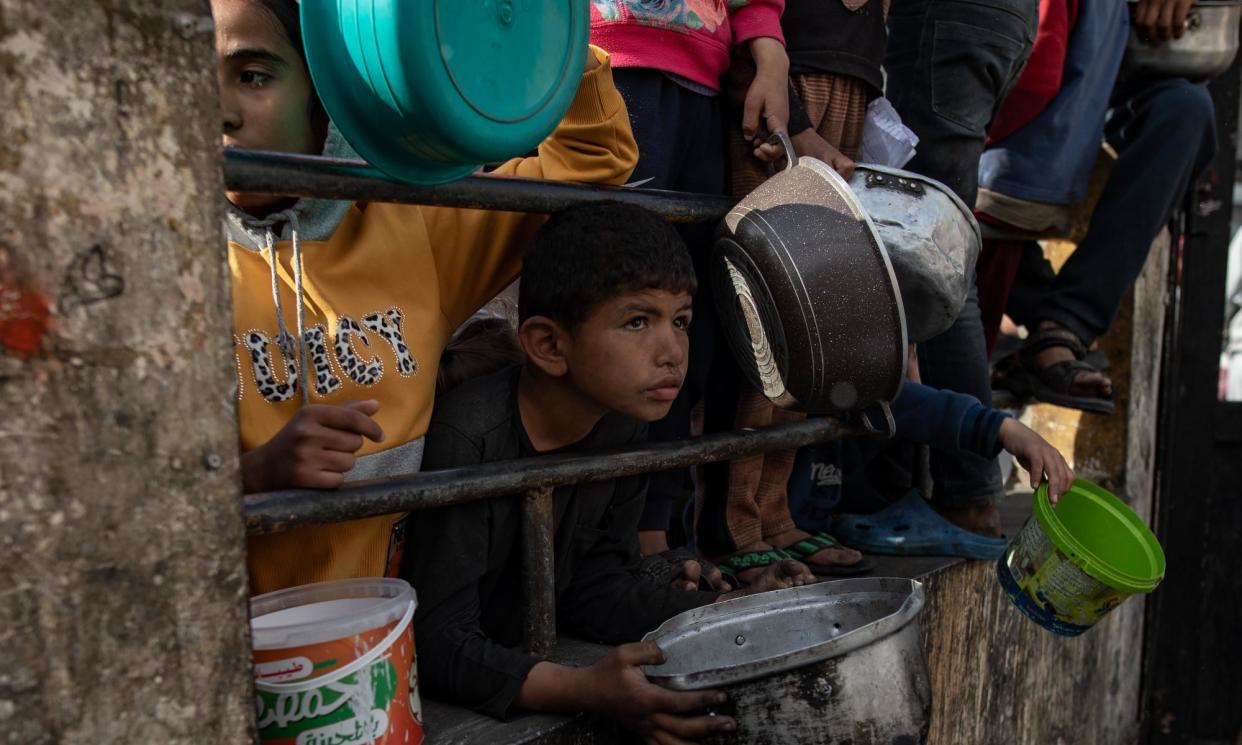 <span>Internally displaced Palestinians gather to collect food aid in Rafah on Friday.</span><span>Photograph: Haitham Imad/EPA</span>