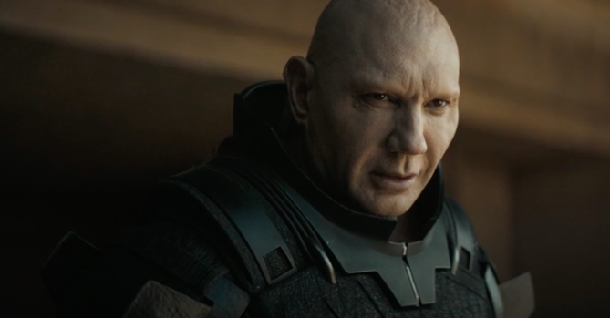 Dave has a bald look and wears an armored outfit in a still from "Dune"