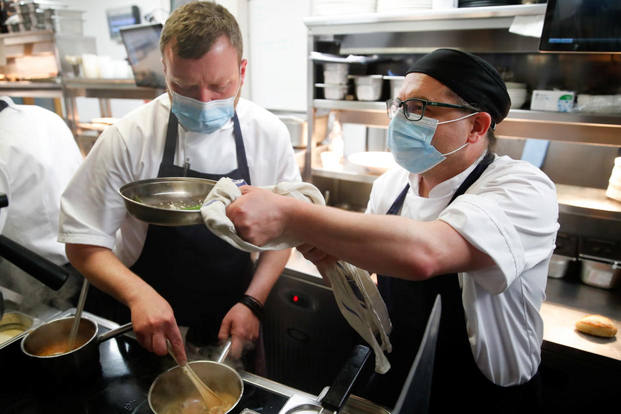 Staff members wear masks while they work at Loxleys Restaurant & Wine Bar, as coronavirus disease (COVID-19) restrictions continue to ease, in Stratford Upon Avon, Britain, May 17, 2021. REUTERS/Andrew Boyers