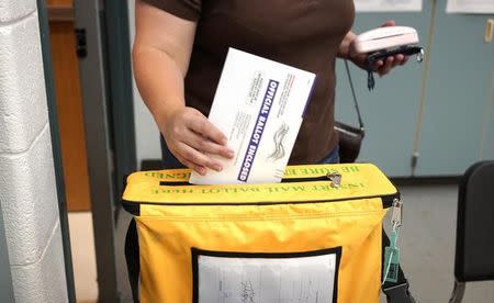 A voter deposits her ballot in the ballot box for the U.S. midterm elections at a polling place in Westminster, Colorado November 4, 2014. REUTERS/Rick Wilking