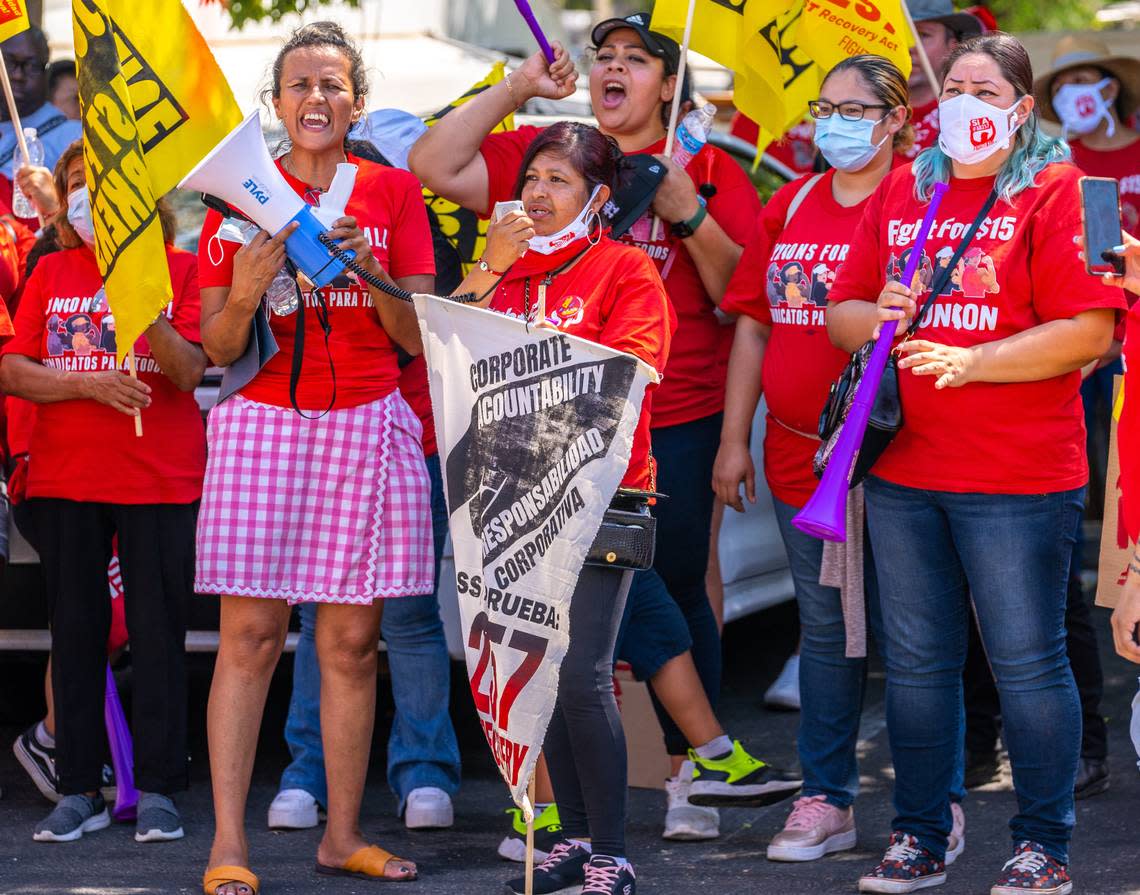 McDonald’s employee Maria Bernal, middle, voices her support of AB 257 through a microphone during a protest at the McDonald’s in North Highlands on Tuesday.