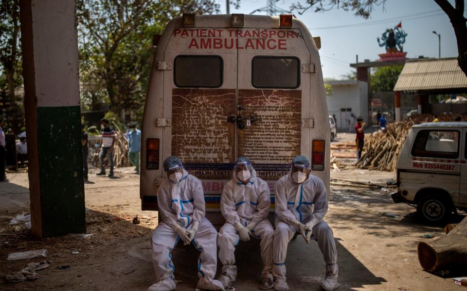 Health workers bring the bodies of coronavirus victims for cremation - Altaf Qadri/AP