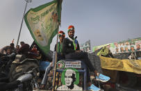 Indian farmers sit on their tractors after arriving at the Delhi-Uttar Pradesh border for Tuesday's tractor rally in New Delhi, India, Monday, Jan. 25, 2021. Thousands of farmers gathered on the borders of Delhi for a massive tractor rally on Tuesday against the three contentious farm laws when India will celebrate its Republic day with a military and cultural parade. The two-month-old old blockade of highways connecting the capital with the country's north continues as the talks have remained deadlocked with the government refusing to scrap the new agricultural reform laws which the farmers say will benefit large corporations. (AP Photo/Manish Swarup)