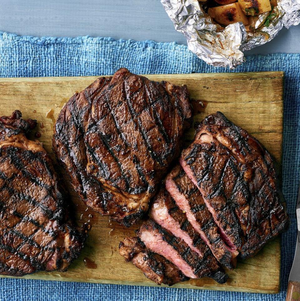 easter dinner ideas lemon pepper grilled rib eyes on wood board