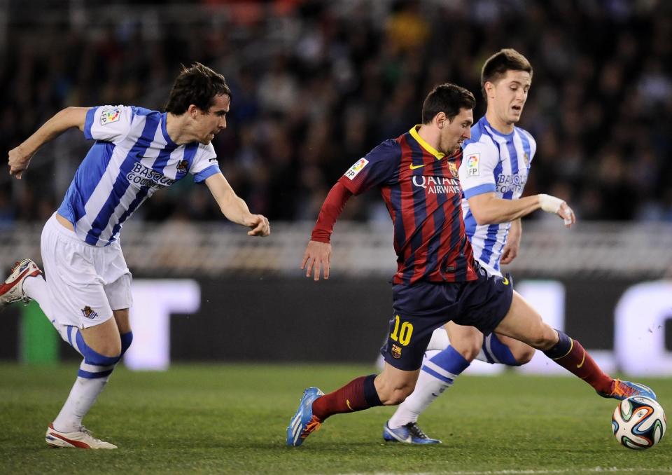FC Barcelona's Lionel Messi of Argentina, center, goes for the ball between Real Sociedad's Jon Gaztanaga, right, and Mikel Gonzalez, left, before to scoring his goal, during their Spanish Copa del Rey semifinal second leg soccer match, at Anoeta stadium, in San Sebastian northern Spain, Wednesday, Feb. 12, 2014. (AP Photo/Alvaro Barrientos)