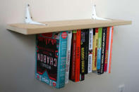 The inverted bookshelf comes from <a href="http://www.instructables.com/id/Inverted-Bookshelf/" rel="nofollow noopener" target="_blank" data-ylk="slk:Instructables user fungus amungus;elm:context_link;itc:0;sec:content-canvas" class="link "> Instructables user fungus amungus</a>, who managed to apparently defy gravity. The secret to this design is a clever placement of elastic, holding each book tied to the shelf. We find it a great way to puzzle your guests, not to mention a cool book unit.