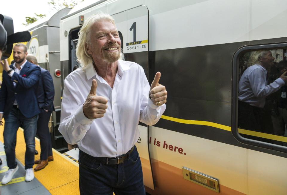 Richard Branson greets passengers in April 2019 as he arrives in West Palm Beach from Miami, where he kicked off the rebranding of Brightline's passenger trains as Virgin Trains USA.