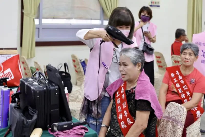 ▲台南市美容業職業工會志工協助得獎的勞工模範母親打點妝髮，使得獎媽媽們亮麗上台接受表揚。（圖／台南市政府提供）