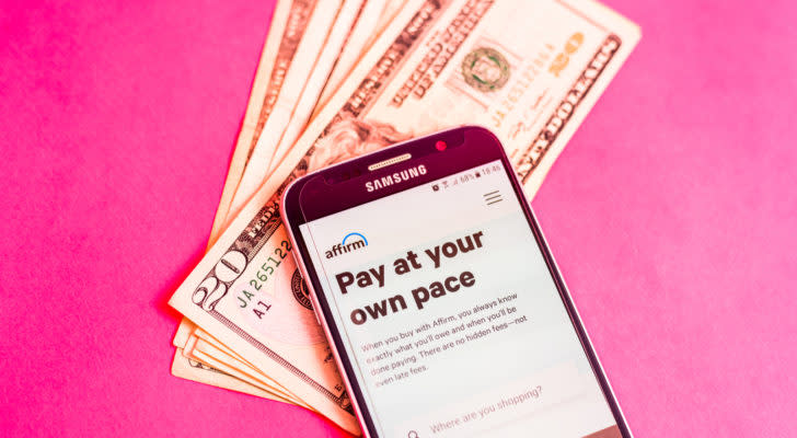 The website for Affirm (AFRM) is shown on a cellphone sitting atop a stack of $20 bills.