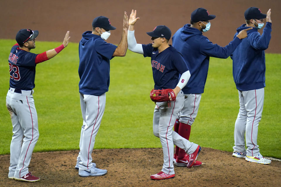 Boston Red Sox players celebrate after defeating the Baltimore Orioles 6-4 in ten innings during a baseball game, Saturday, April 10, 2021, in Baltimore. The Red Sox won 6-4 in ten innings. (AP Photo/Julio Cortez)