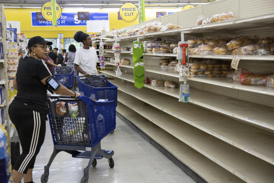 People shop for supplies before the arrival of Hurricane Dorian, in Freeport, Bahamas, Friday, Aug. 30, 2019. Forecasters say the hurricane is expected to keep on strengthening and become a Category 3 later in the day. (AP Photo/Tim Aylen)