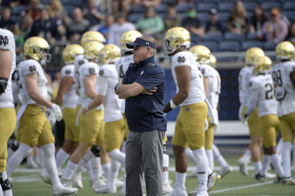 Notre Dame head coach Brian Kelly, center, watches warmups before the Camping World Bowl NCAA college football game against Iowa State Saturday, Dec. 28, 2019, in Orlando, Fla. (AP Photo/Phelan M. Ebenhack)