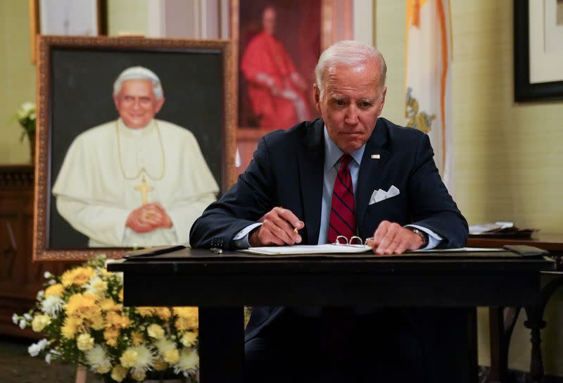 U.S. President Joe Biden signs a book of condolences for former Pope Benedict, in Washington