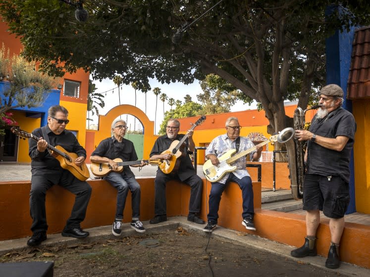 Los Angeles, CA - July 22: Los Lobos: left to right: Cesar Rosas, singer, songwriter and guitarist, Louie Perez, songwriter, percussionist and guitarist, David Hidalgo, singer-songwriter, accordion, violin, 6-string banjo, cello, requinto jarocho, percussion, drums and guitar, Conrad Lozano, bass, and Steve Berlin, saxophonist, keyboardist and record producer, are photographed at Plaza de la Raza on Thursday, July 22, 2021 in Los Angeles, CA. Archetypal LA band Los Lobos will release Native Sons, which features their version of classic L.A. songs including Sail On, Sailor (Beach Boys), The World Is A Ghetto (WAR) and Flat Top Joint (The Blasters). Now in their 40th year as a band, Los Lobos shoots a video for the National Endowment for the Arts at Plaza de la Raza in Lincoln Heights. (Allen J. Schaben / Los Angeles Times)