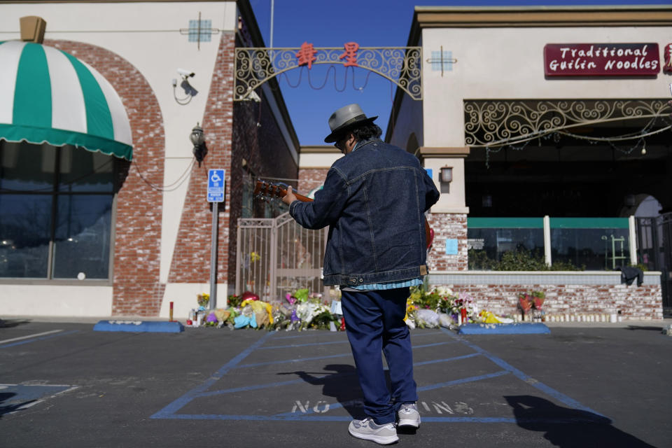 Gabriel Alexander plays a guitar and sings near a memorial outside the Star Ballroom Dance Studio on Tuesday, Jan. 24, 2023, in Monterey Park, Calif. A gunman killed multiple people at the ballroom dance studio late Saturday amid Lunar New Years celebrations in the predominantly Asian American community. (AP Photo/Ashley Landis)