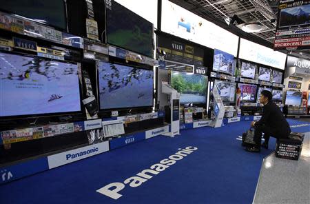 A man looks at Panasonic Corp's Viera televisions displayed at an electronics store in Tokyo October 31, 2013. REUTERS/Toru Hanai