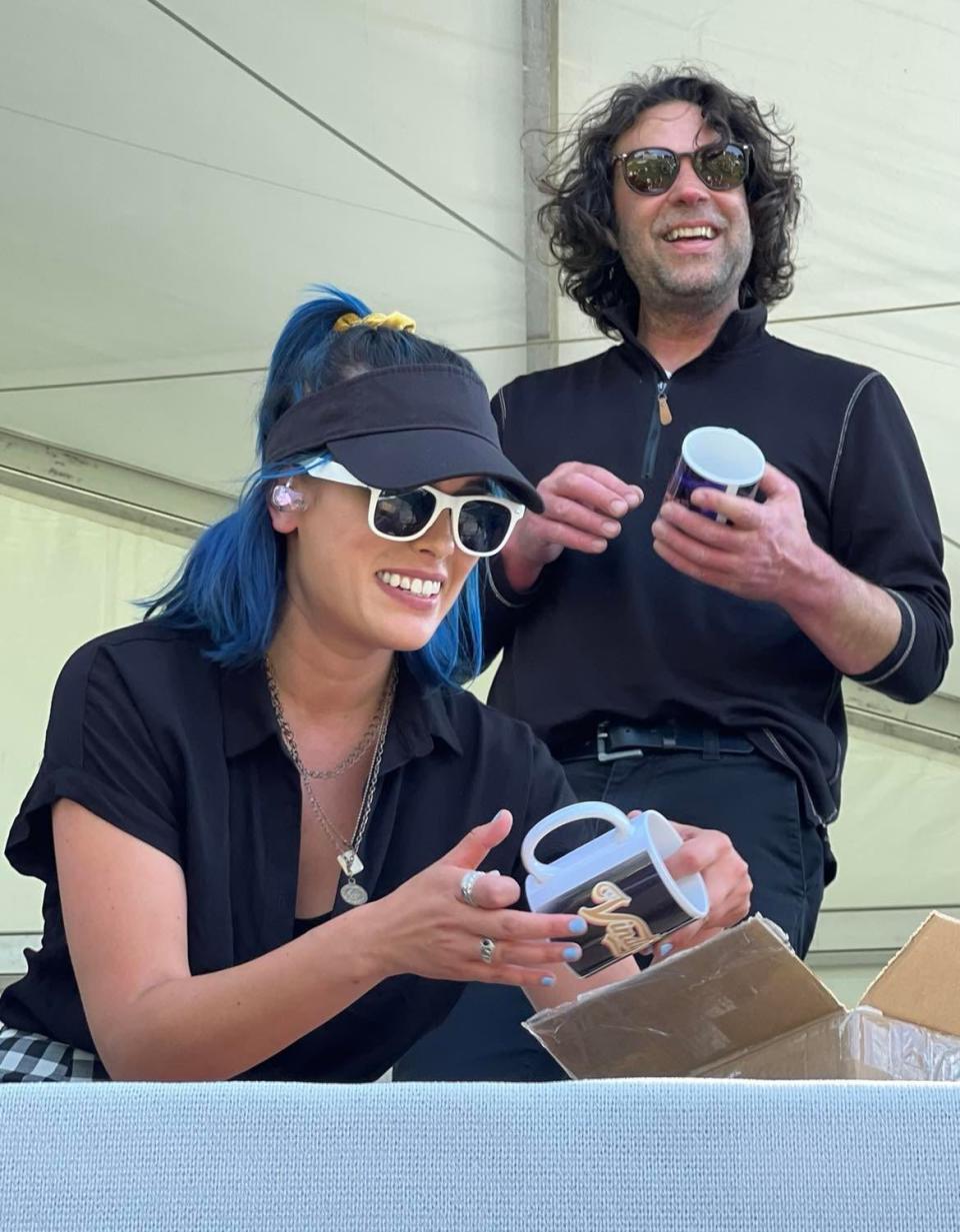 Jackie Popovec and Rick Deak of The Vindys express surprise after receiving personalized coffee mugs as a gift from fans following a recent performance at the Firestone Country Club in Akron.