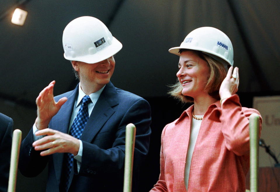 FILE - In this May 4, 2001, file photo, Microsoft Chairman Bill Gates contends with an ill-fitting hard hat while his wife, Melinda Gates, looks on in Seattle at the groundbreaking of the University of Washington's new law school facility, William H. Gates Hall. The couple announced Monday, May 3, 2021, that they are divorcing. (AP Photo/Andy Rogers, File)