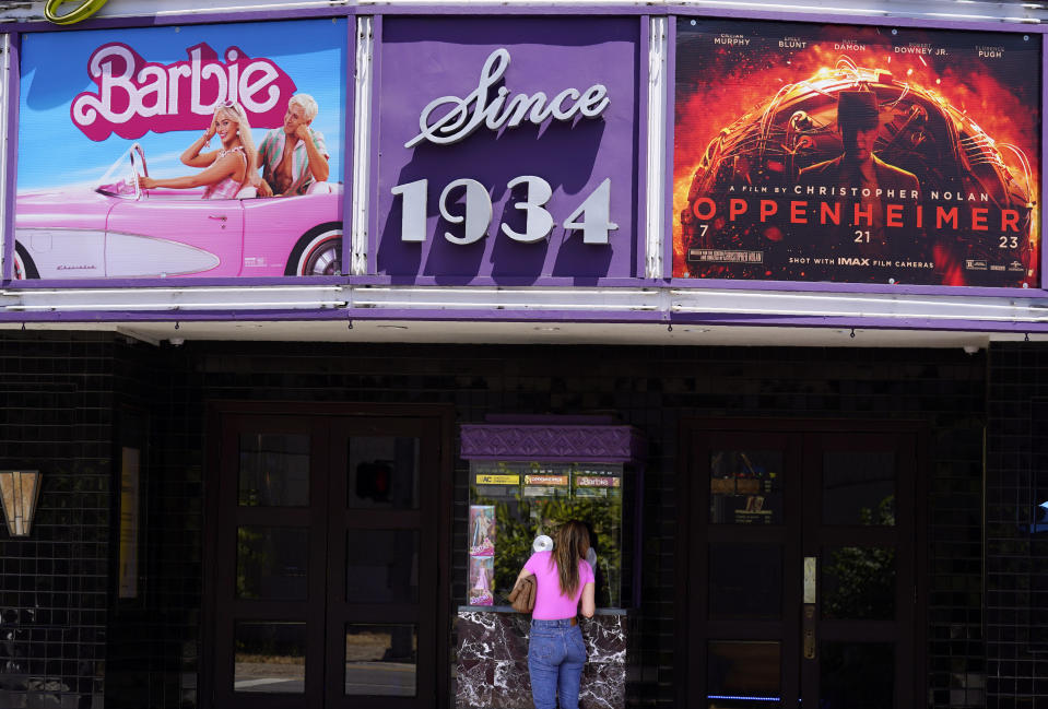 A patron buys a movie ticket underneath a marquee featuring the films "Barbie" and "Oppenheimer" at the Los Feliz Theatre, Friday, July 28, 2023, in Los Angeles. (AP Photo/Chris Pizzello)