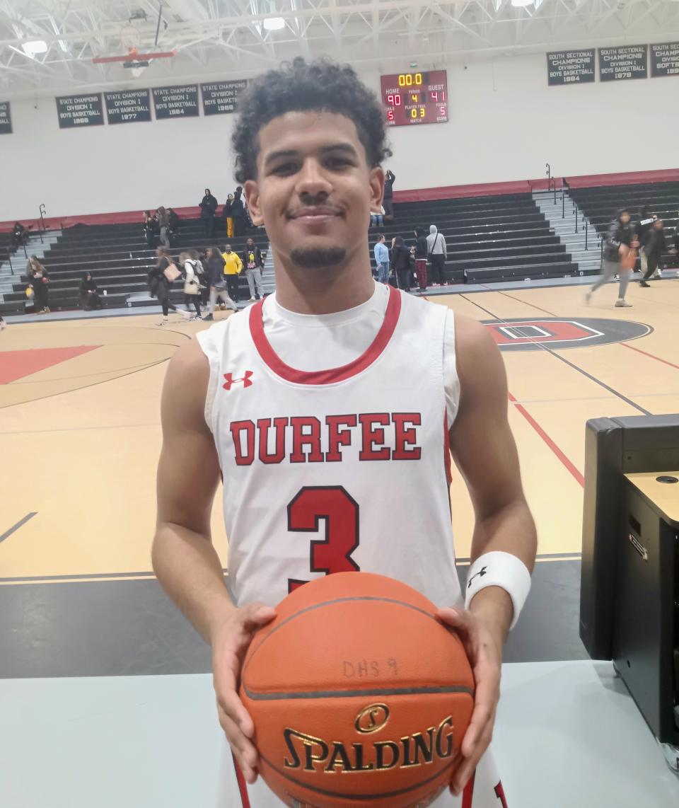 Durfee's Jeyden Espinal stands with the basketball after the Hilltoppers beat Brighton in the opening round of the Thomas 'Skip' Karam holiday tournament at B.M.C. Durfee High School.