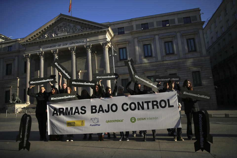 Activists holding banners in the shape of missiles and a banner reading in Spanish "Arms under control" protest against the sale of weapons to Saudi Arabia in front of the Spanish Parliament in Madrid, Wednesday, Oct. 24, 2018. Spain’s prime minister says his government will fulfill past arms sales contracts with Saudi Arabia despite his “dismay” over the “terrible murder” of journalist Jamal Khashoggi. (AP Photo/Andrea Comas)