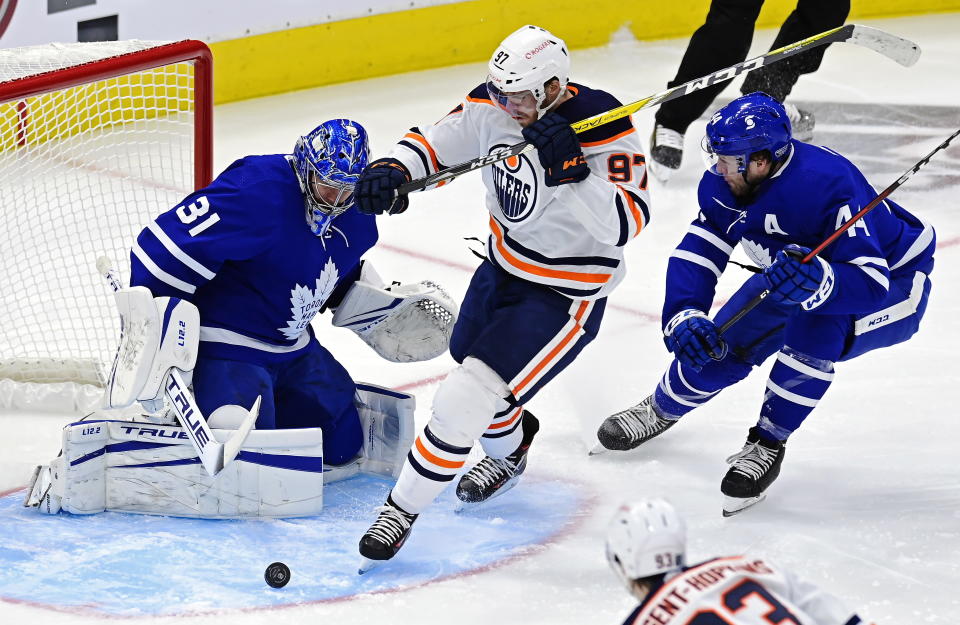 Toronto Maple Leafs goaltender Frederik Andersen (31) makes a save on Edmonton Oilers' Connor McDavid (97) as Maple Leafs' Morgan Rielly (44) defends during the second period of an NHL hockey game Friday, Jan. 22, 2021, in Toronto. (Frank Gunn/The Canadian Press via AP)