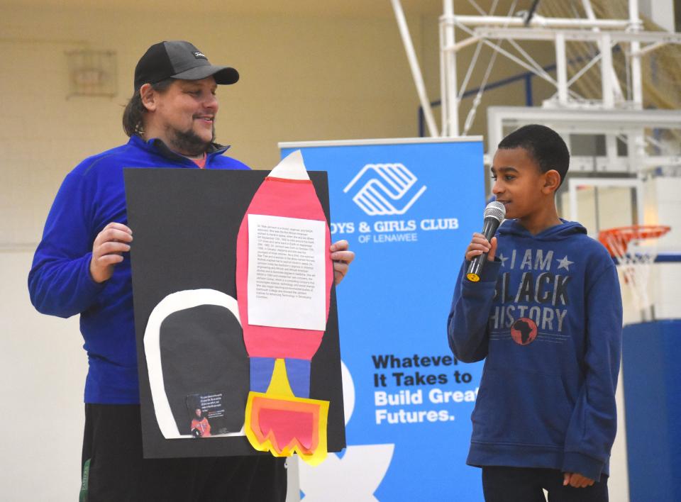 Nigel John, right, a fourth grade student at Lincoln Elementary School in Adrian, presents about Mae Jemison, an American engineer, physician, and former NASA astronaut, who became the first Black woman to travel into space when she served as a mission specialist aboard the Space Shuttle Endeavour, during the Boys & Girls Club of Lenawee's inaugural Black History Month biography fair. Assisting John with holding his poster project is Boys & Girls Club Director of Programs Jeremy Fetters.