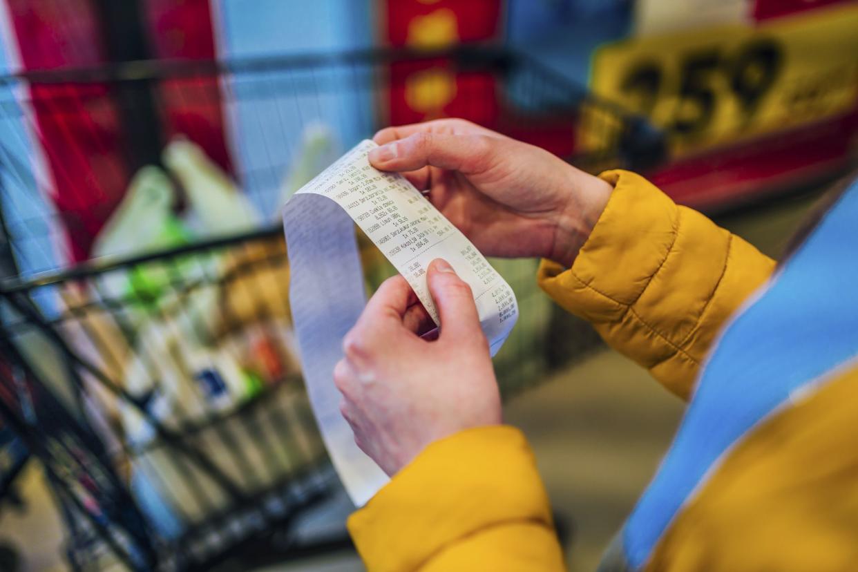 Woman looking receipt from a supermarket