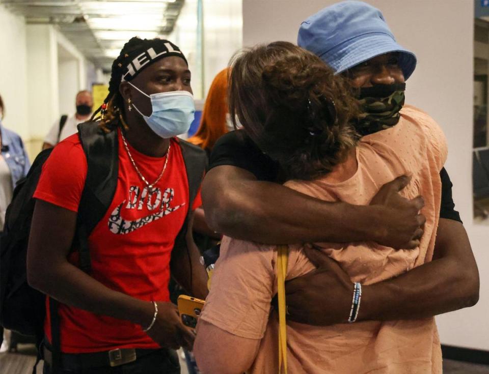 On Thursday, July 15, 2021, brothers Lovinsky, 27, left, and John Nalus, 21, right, is greeted by a family friend, Randy Kurtz, center, upon their arrival in the United States after being detained in the Dominican Republic just short of a year on an alleged drug charge.