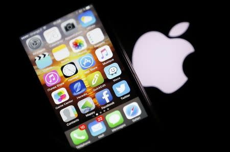 An Apple iPhone is pictured next to the logo of Apple in Bordeaux, southwestern France, February 26, 2016. REUTERS/Regis Duvignau