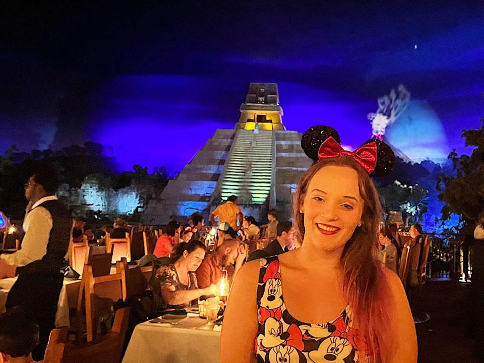 Jenna Clark at epcot, san angel inn restaurante with pyramid in the back