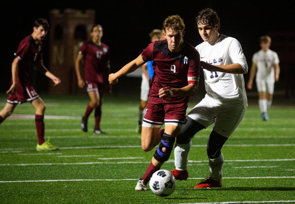 Newark's Noah Dagois (9) takes the ball around Lancaster's Jacob Deuscher (11) during a Division I boys soccer tournament game at White Field on Oct. 19, 2021. The Wildcats dominated the Golden Gales 5-0.