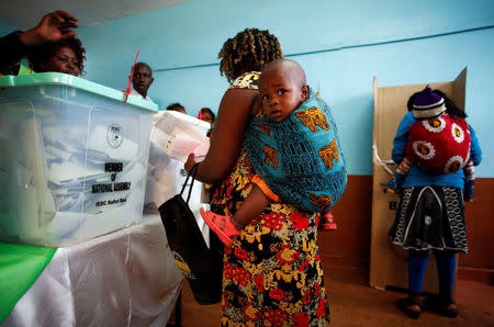 Women carrying babies cast their vote in Gatundu in Kiambu county, Kenya August 8, 2017. REUTERS/Baz Ratner