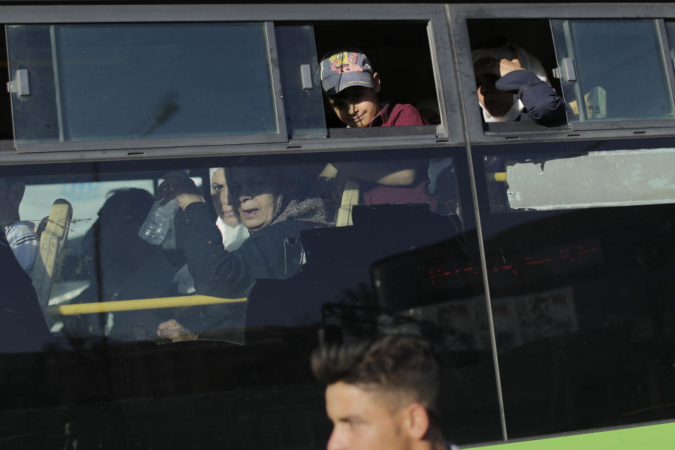 In this Wednesday, July 24, 2019 photo, Syrian commuters on a bus get stuck in a traffic jam during rush hour in the Syrian capital, Damascus. Syrians say it’s even harder now to make ends meet than it was during the height of their country’s civil war because of intensified U.S and European sanctions. Prices have leaped because of restrictions on oil imports, the value of the currency has plunged in recent months. Most of the country is now below the poverty line, earning less than $100 a month. (AP Photo/Hassan Ammar)