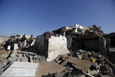 People gather at the site of an air strike at a residential area near Sanaa Airport March 26, 2015. REUTERS/Khaled Abdullah