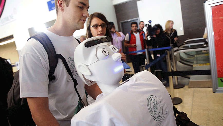 Alexander Herzog, a doctoral student at Max Planck Society, pushes 'Athena', the first 'humanoid' robot to fly as a passenger. Photo: Reuters