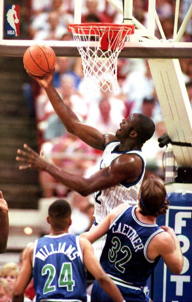 O'Neal takes to the air for two points over Minnesota Timberwolves guard Michael Williams and forward Christian Laettner during the first half of their game in Orlando, FL, 20 April 1994. (TONY RANZE/AFP/Getty Images)