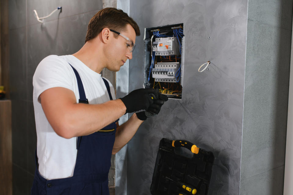 A view of a worker fixing an electrical component.