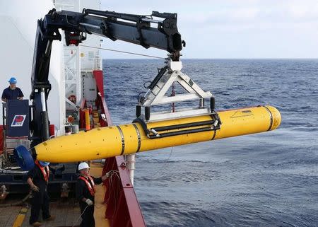 Crew aboard the Australian Defence Vessel Ocean Shield move the U.S. Navy's Bluefin-21 autonomous underwater vehicle into position for deployment in the southern Indian Ocean to look for the missing Malaysia Airlines flight MH370, April 14, 2014 in this handout picture released by the U.S. Navy. REUTERS/U.S. Navy photo by Mass Communication Specialist 1st Class Peter D. Blair/Handout via Reuters