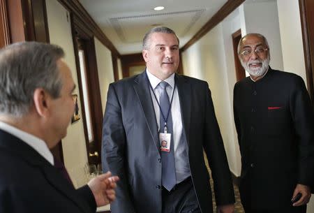 Sergey Aksyonov (C), the leader of Crimea, the former Ukrainian territory annexed by Russia, walks inside a hotel after having his lunch as Indian businessman Gul Kripalani (R) watches, in New Delhi December 11, 2014. REUTERS/Anindito Mukherjee