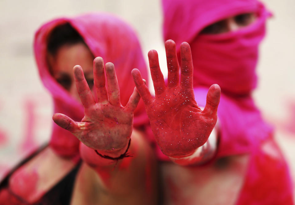 In this Sept. 6, 2019 photo, women with her hands covered in red paint protest against the murders of sex workers, at Mexico City's iconic Angel of Independence. (AP Photo/Marco Ugarte)